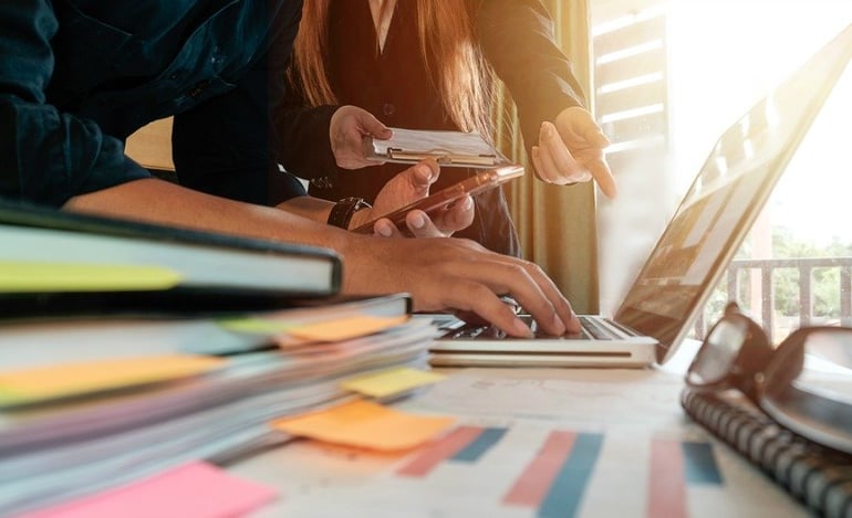 Man and Woman Sitting at a Desk in Office Man and Woman Sitting at a Desk in Office